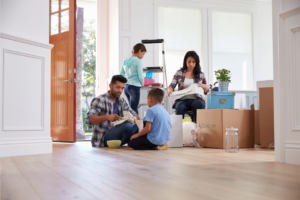A family sitting on the floor preparing to move house
